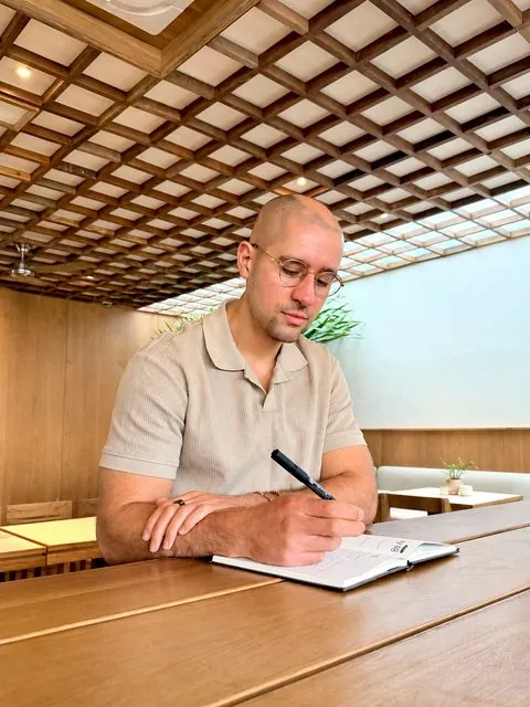 Logan writing in the One Story journal